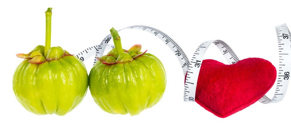 garcinia cambogia fresh fruit with red heart and measuring tape,